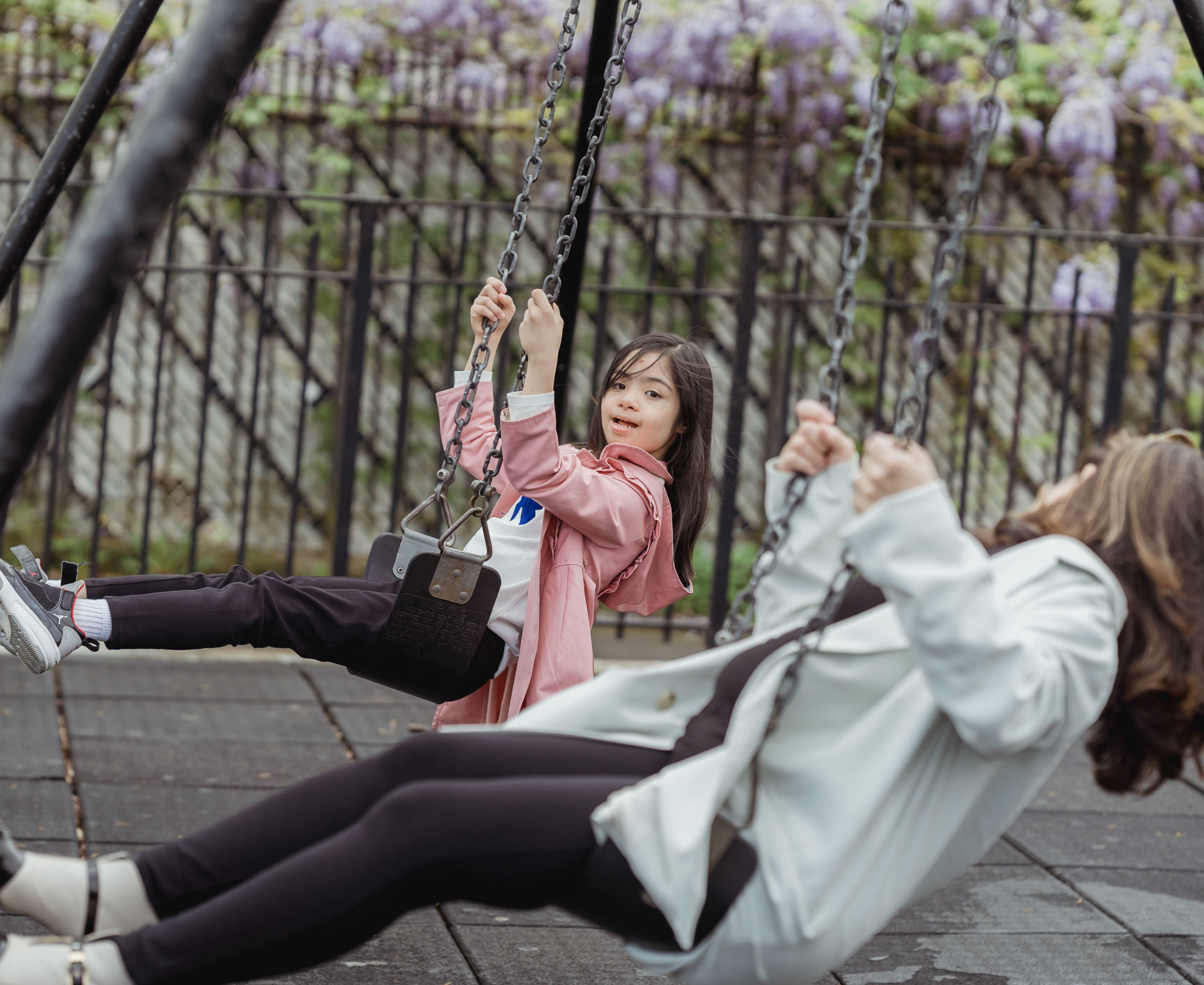A young girl with special needs on a playground swing.